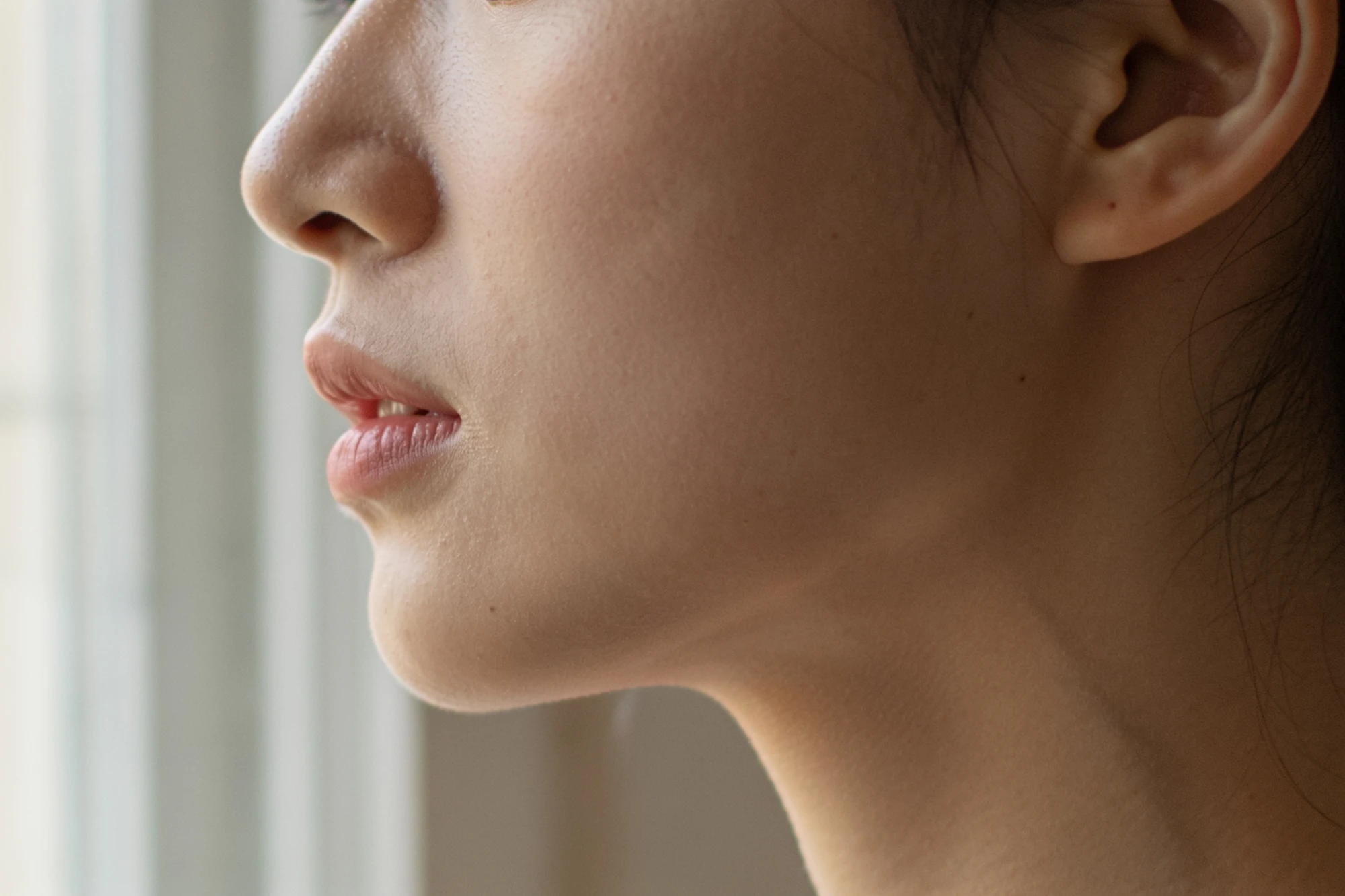 Close view of a cheek with fine surface lines in soft light, dry skin vs dehydrated skin